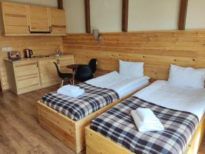 two beds in a room with a kitchen and a table at New Gudauri GoodHost Apartments in Gudauri