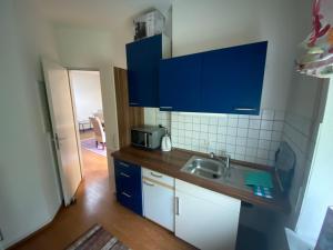 a kitchen with blue cabinets and a sink at Ferienwohnung Aktuell in Memmingen +1 photo
