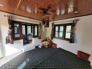 an empty room with a ceiling fan and windows at OYO Home Fatima's Homestay in Wāngom