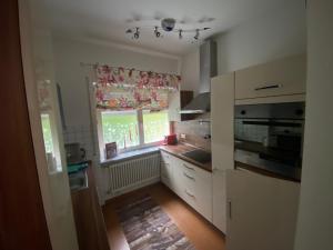 a kitchen with white cabinets and a window at Ferienwohnung Aktuell in Memmingen