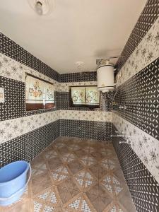 a bathroom with black and white tiles and a tub at OYO Home Fatima's Homestay in Wāngom