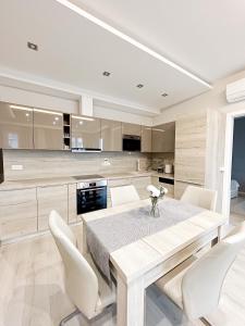 kuchnia z drewnianym stołem i białymi krzesłami w obiekcie MyFlat Viewpoint 57 w Siófoku