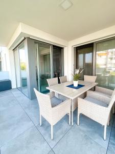 patio ze stołem i krzesłami na ganku w obiekcie MyFlat Viewpoint 57 w Siófoku