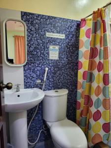 a bathroom with a toilet and a sink at Rooms R Us - Voyagers Palace in Puerto Princesa City
