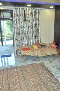 een groot bed in een kamer met een gordijn bij POP Sneha Homestay in Dhār Khurd