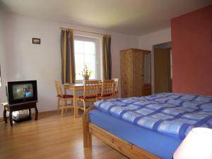 - une chambre avec un lit, une table et une télévision dans l'établissement Penzion Polarka, à Mariánské Lázně