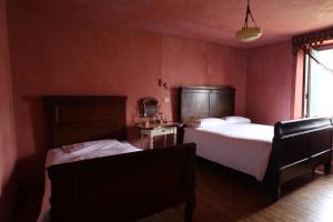 ArtogneにあるAgriturismo Le Friseのベッドルーム1室(ベッド2台、椅子、窓付)