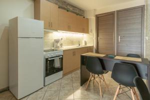 een keuken met een koelkast en een tafel en stoelen bij Sunshine Apartment 2 in Alexandroupoli