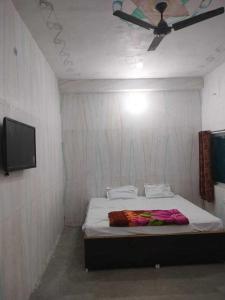een slaapkamer met een bed en een plafondventilator bij SPOT ON Sana Guest House in Lucknow