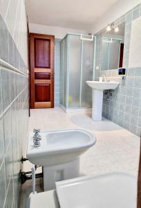 a bathroom with a sink and a toilet and a shower at La casa al mare, Pittulongu in Olbia