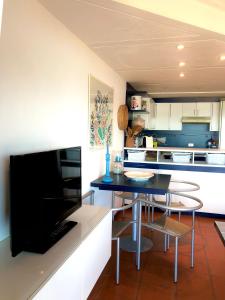 eine Küche mit einem Esstisch und einem TV in der Unterkunft Marinella Sky View in Marinella
