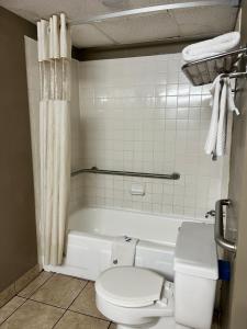 a bathroom with a toilet and a bath tub at Devils Lake Inn in Devils Lake