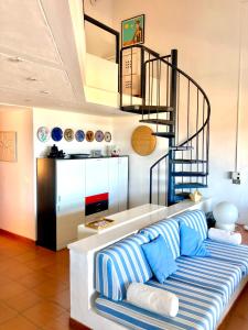 a living room with a couch and a spiral staircase at Marinella Sky View in Marinella