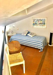 ein kleines Schlafzimmer mit einem Bett und einem Stuhl in der Unterkunft Marinella Sky View in Marinella