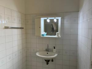 La salle de bains blanche est pourvue d'un lavabo et d'un miroir. dans l'établissement Angelos Furnished Apartments, à Amoopi