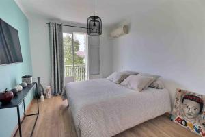 a bedroom with a bed and a large window at Charmant T2 Climatisé avec Parking in Ajaccio