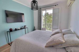 1 dormitorio con 1 cama, TV y ventana en Charmant T2 Climatisé avec Parking, en Ajaccio