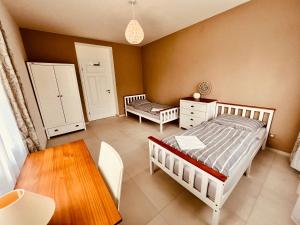 1 Schlafzimmer mit 2 Betten, einem Tisch und einem Stuhl in der Unterkunft Lilac House - holiday and relaxation house in Ohrobec