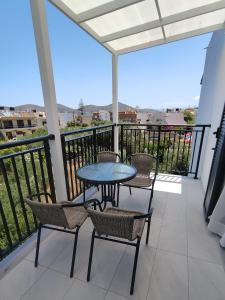 een patio met een tafel en stoelen op een balkon bij Emilia Apartments in Elounda