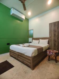 a large bed in a room with a green wall at Hotel Aurelia Pearl in Patna