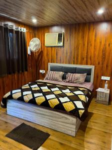 Royal Tree Cafe And Resort في دهرادون: غرفة نوم بسرير في جدار خشبي