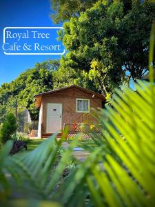 Royal Tree Cafe And Resort في دهرادون: كابينة خشبية صغيرة مع باب أبيض