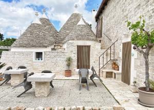 a patio with tables and chairs and a building at Trulli Caroli in Locorotondo