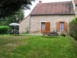 a stone house with a picnic table and an umbrella at Gîte champêtre avec jardin clos, près du lac d'Eguzon et Gargilesse-Dampierre ! - FR-1-591-127 in Orsennes +12 photos