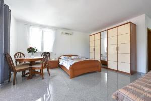 1 dormitorio con 1 cama, mesa y sillas en Villa Annaleah, en Dubravice