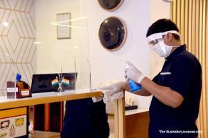 a man in a room with a mask and gloves at SPOT ON Hotel Rudra in Kulu