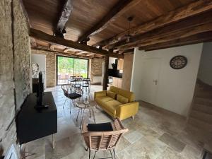 a living room with a yellow couch and chairs at Les Noyers De Gaudelle in Saint-Sozy