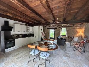 eine Küche und ein Esszimmer mit einem Tisch und Stühlen in der Unterkunft Les Noyers De Gaudelle in Saint-Sozy