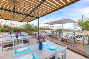 a restaurant with tables and chairs and an umbrella at Banana Moon in Adelianos Kampos