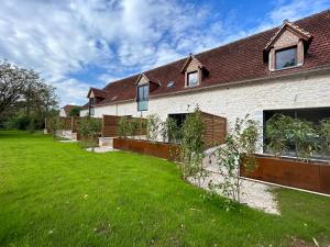 ein Haus mit grünem Rasen davor in der Unterkunft Les Noyers De Gaudelle in Saint-Sozy