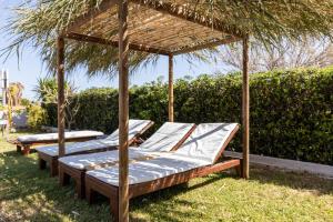 a group of beds sitting under a pergola at Banana Moon in Adelianos Kampos