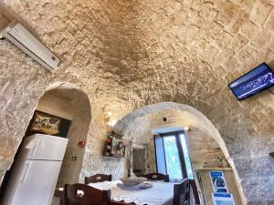 a dining room with a table and a refrigerator at Trulli Caroli in Locorotondo