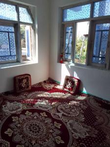a room with a bed with two chairs and windows at POP Masrat Homestay 
