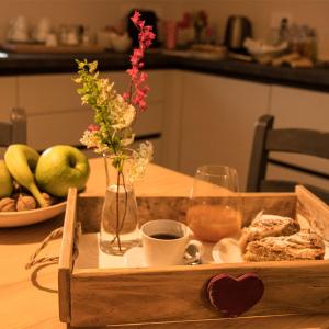 een houten dienblad met eten en een kopje koffie op een tafel bij B&B Belelì Daramba in Cuneo