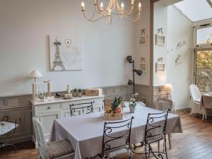 cocina y comedor con mesa y lámpara de araña en La Villa Côté Cour, en Dinan