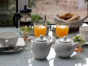 una mesa con dos tazas de zumo de naranja y pan en La Villa Côté Cour en Dinan