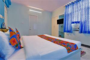 FabExpress Anuja في جايبور: غرفة نوم بسرير ابيض كبير بجدران زرقاء