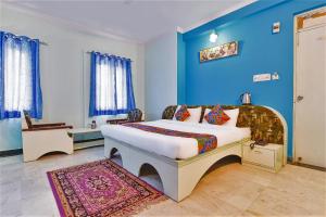 Schlafzimmer mit einem Bett mit blauer Wand in der Unterkunft FabExpress Anuja in Jaipur
