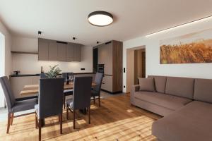 a living room and dining room with a couch and a table at Alpenglow Apartments in Collalbo