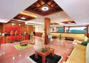 uma grande sala de estar com um sofá e uma mesa em Collection O Pgs Neelamabari em Neriyamangalam