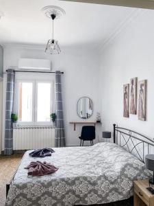 a white bedroom with a bed and a mirror at Castlevania- Traditional house in the Castle in Naxos Chora