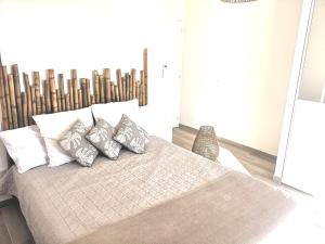 um quarto com uma cama com quatro almofadas em BELLA CORSICA em Ajaccio