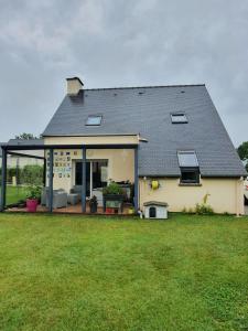 une maison avec une grande pelouse devant dans l'établissement Chambre chez l'Habitant La Rance, à Plouër-sur-Rance