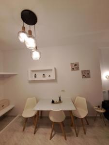 una sala da pranzo con tavolo e sedie bianchi di Studios Irineos a Perissa