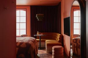 Ember Locke Kensington في لندن: غرفة بها أريكة وطاولة ونوافذ