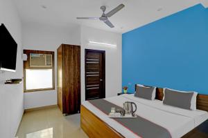 een slaapkamer met een bed, een wastafel en een plafondventilator bij Collection O Hotel Daffodils in Gurgaon